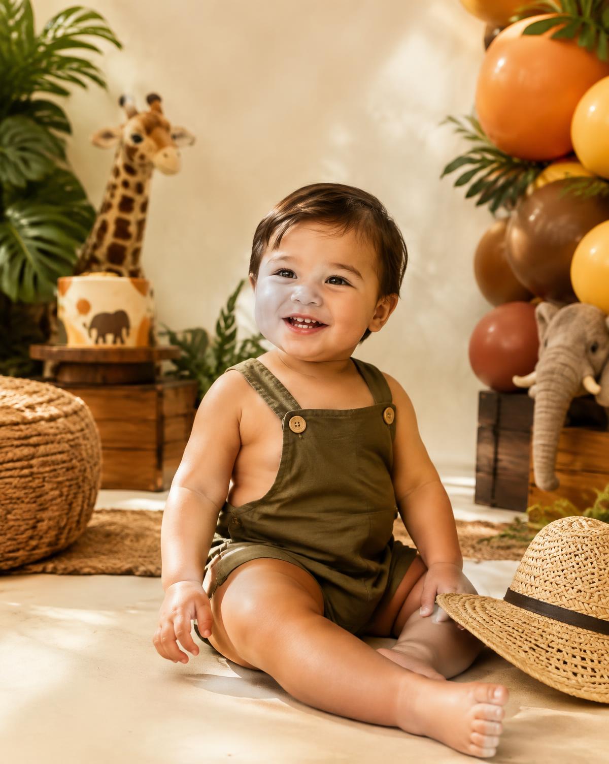 A smiling toddler at a safari birthday set